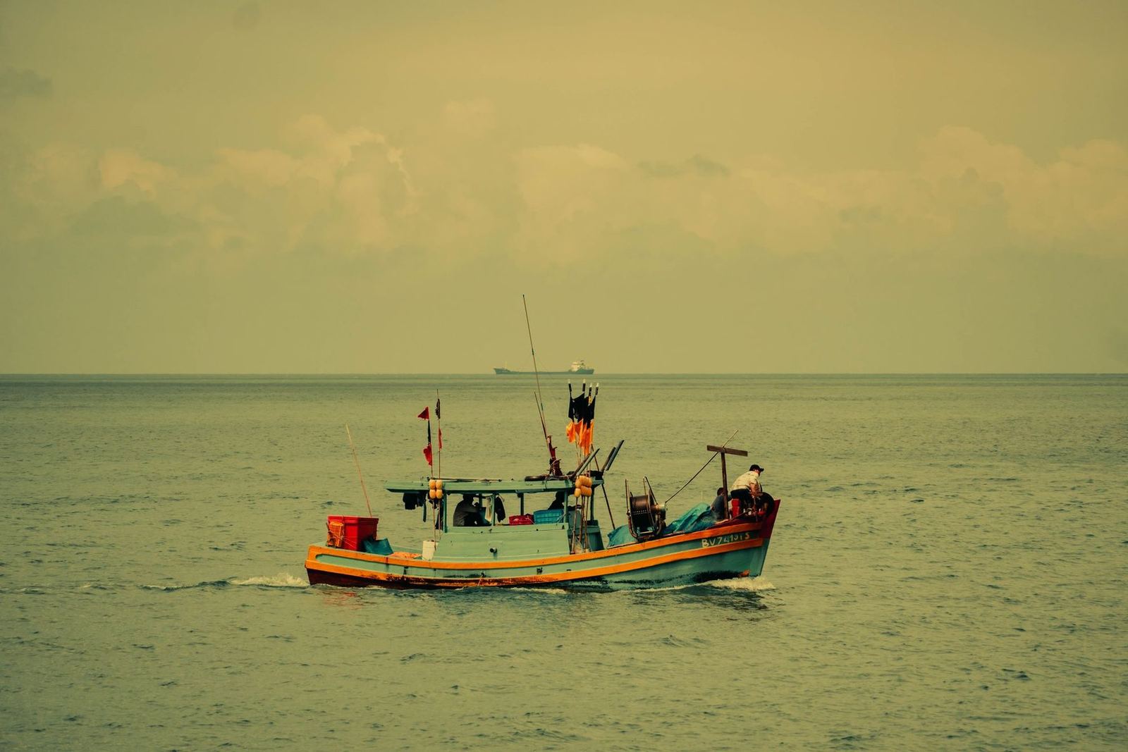 A boat on hazy open water at the end of the day